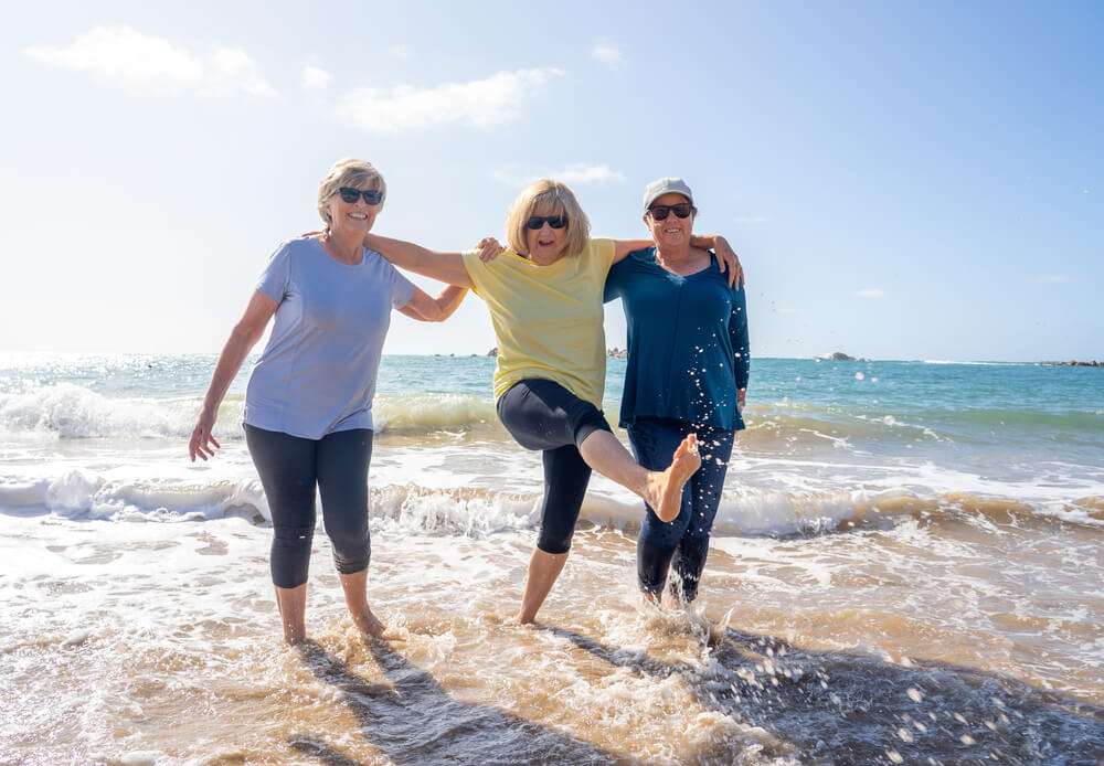 Image shows senior women having fun on the beach.